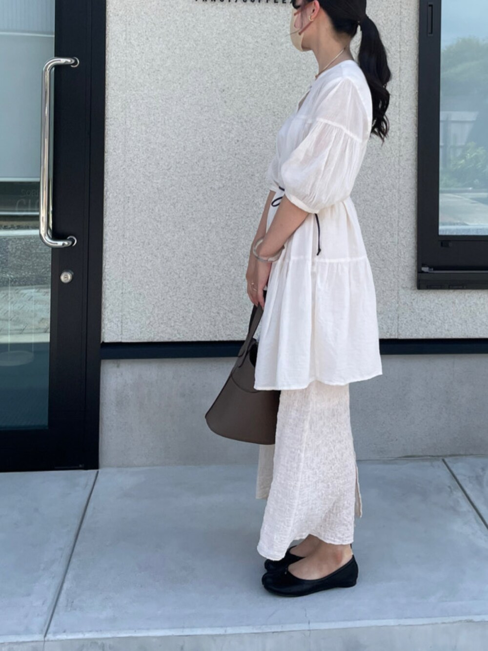 ベージュ系のスカート、グレー系のバッグ、ブラック系のバレエシューズを着用したレディースの夏コーディネートの3枚目の写真