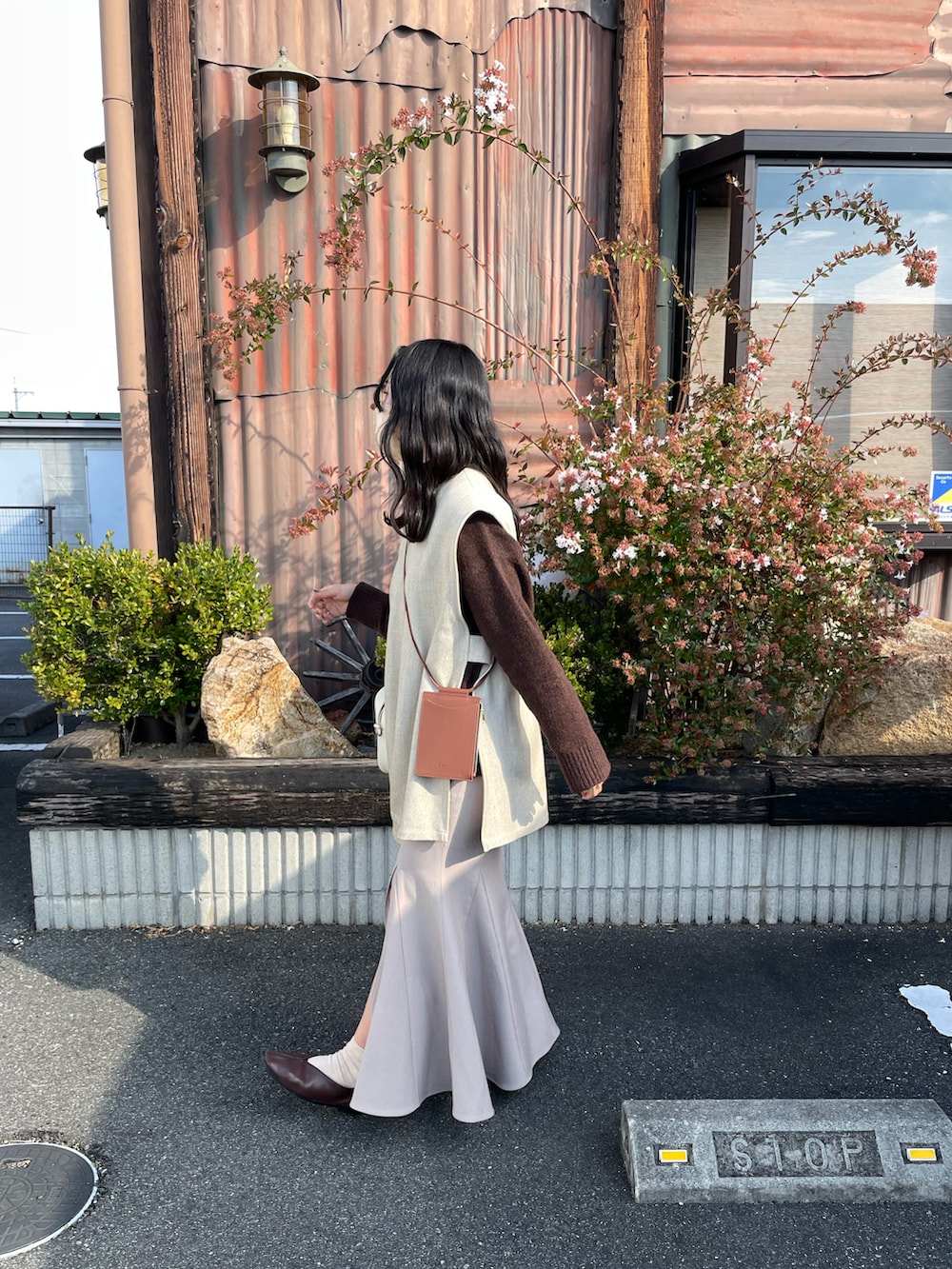 ホワイト系のボストンバッグ、ベージュ系のスカート、ブラウン系のニット/セーターを着用したレディースの冬コーディネートの3枚目の写真