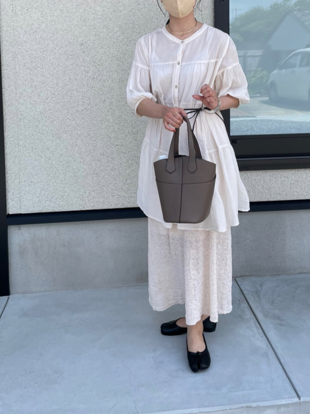 ベージュ系のスカート、グレー系のバッグ、ブラック系のバレエシューズを着用したレディースの夏コーディネートの2枚目の写真