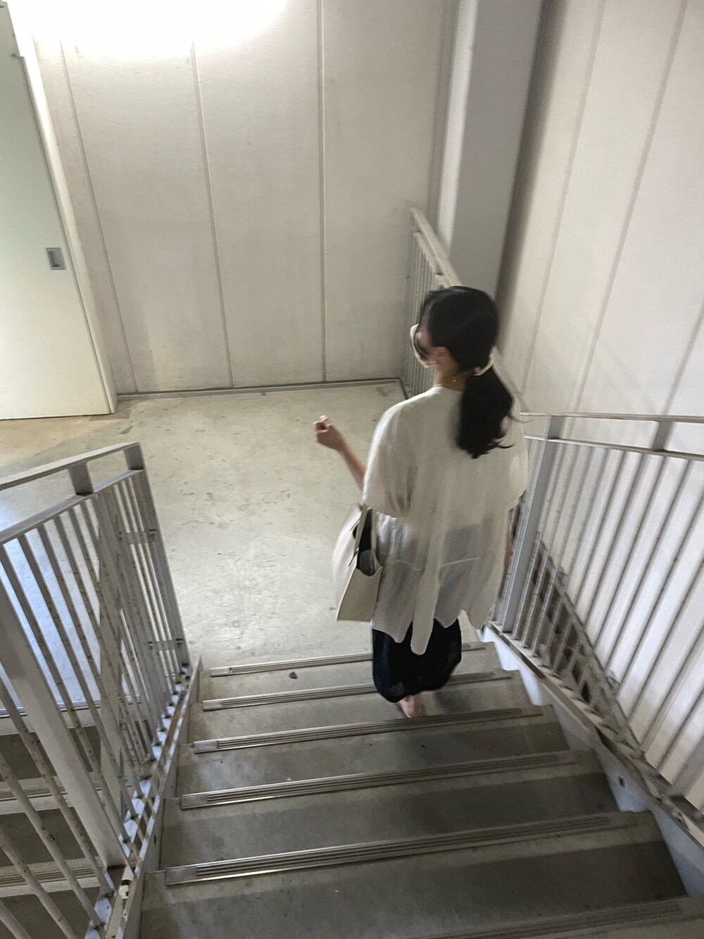 ベージュ系のハンドバッグ、ホワイト系のサンダル、ベージュ系のシャツ/ブラウスを着用したレディースの夏コーディネートの2枚目の写真