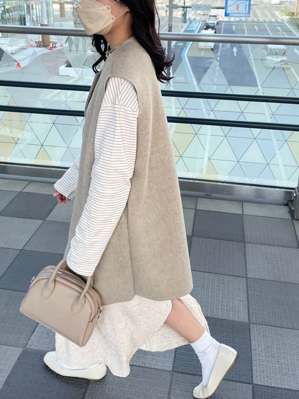ベージュ系のボストンバッグ、ベージュ系のその他アウター、ブラウン系のその他トップスを着用したレディースの秋コーディネートの4枚目の写真