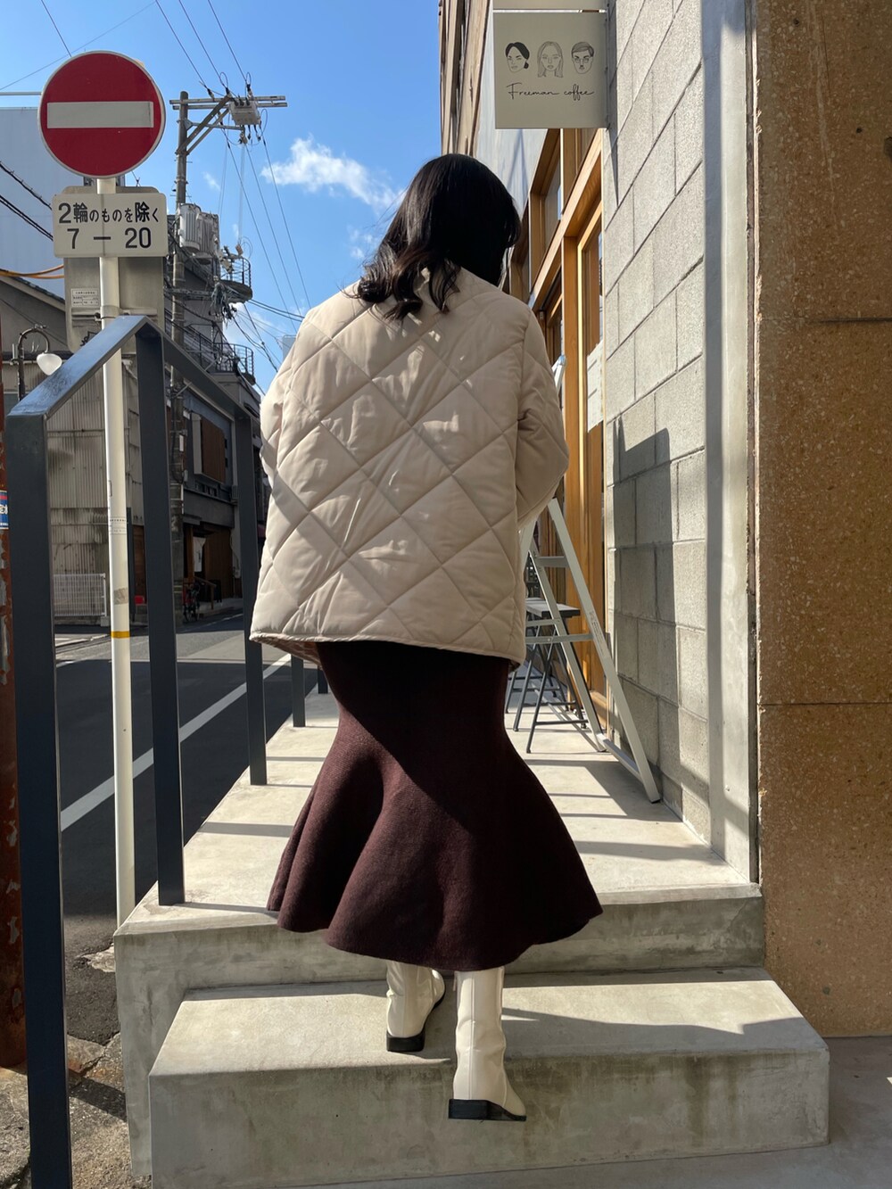 ブラウン系のボストンバッグ、ベージュ系のニット/セーター、ホワイト系のブーツを着用したレディースの冬コーディネートの3枚目の写真