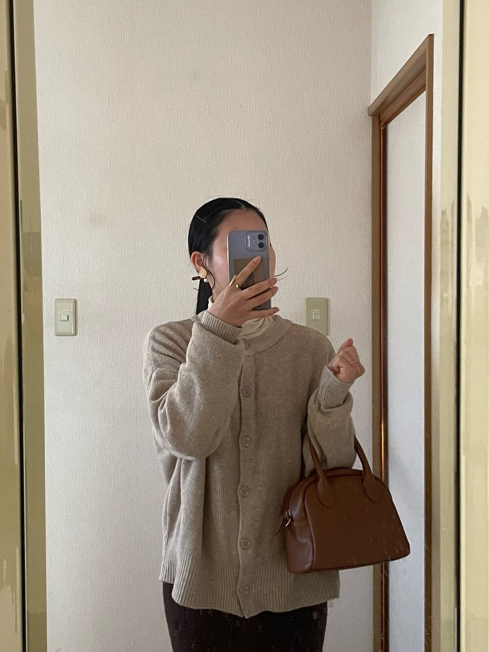 ブラウン系のボストンバッグ、ブラウン系のスカート、ブラウン系のパンプスを着用したレディースの秋コーディネートの4枚目の写真