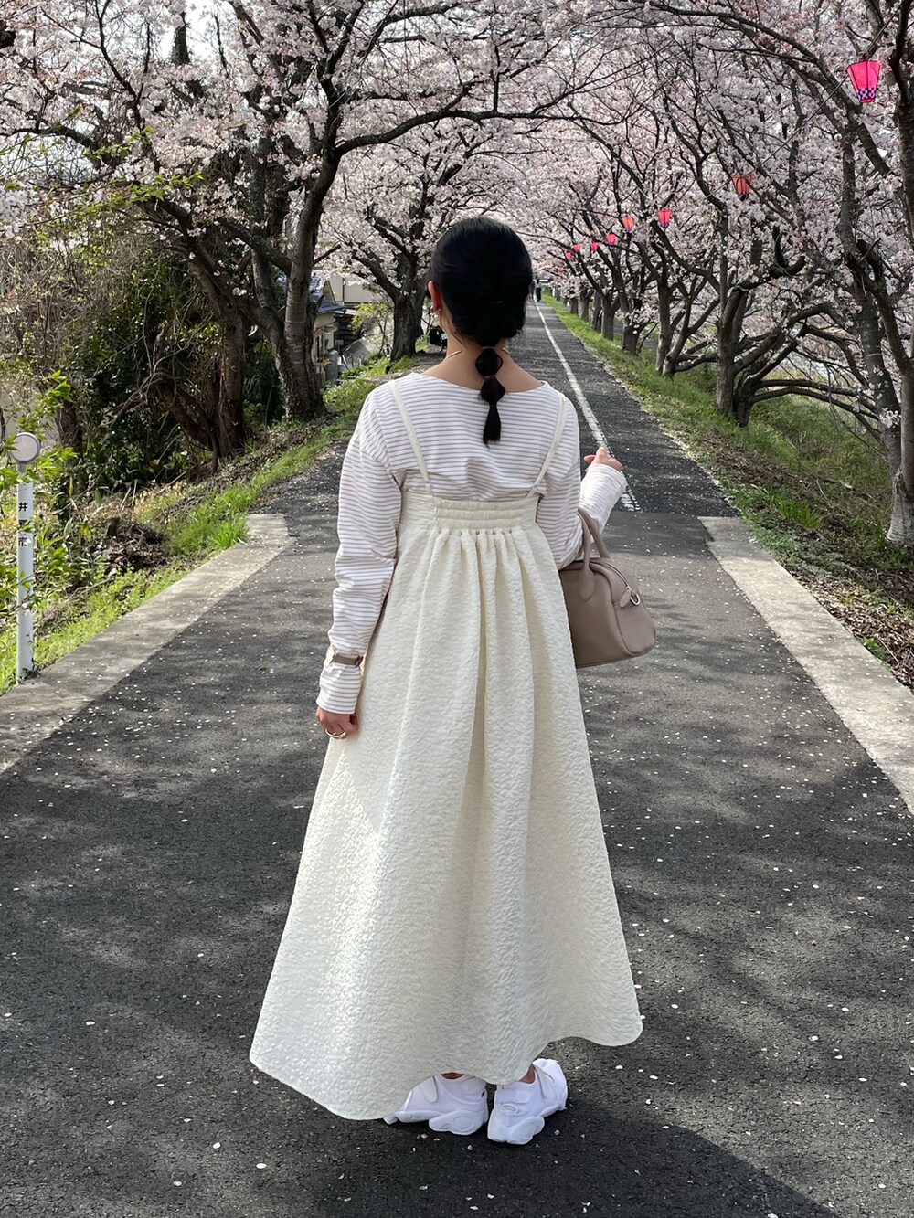 ホワイト系のスニーカー、ベージュ系のボストンバッグ、ブラウン系のその他トップスを着用したレディースの春コーディネートの2枚目の写真