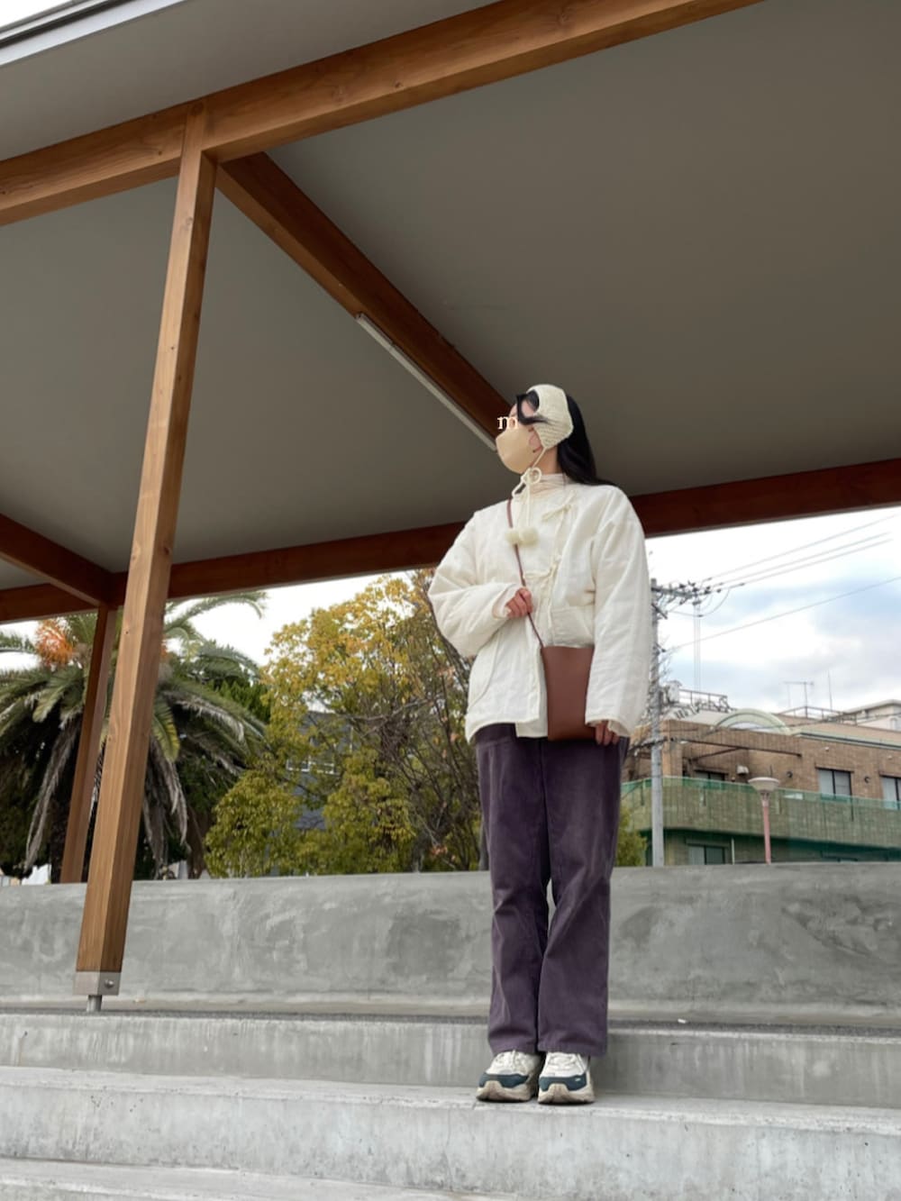 ホワイト系のその他アウター、ホワイト系のその他トップス、ブラウン系のショルダーバッグを着用したレディースの冬コーディネートの3枚目の写真