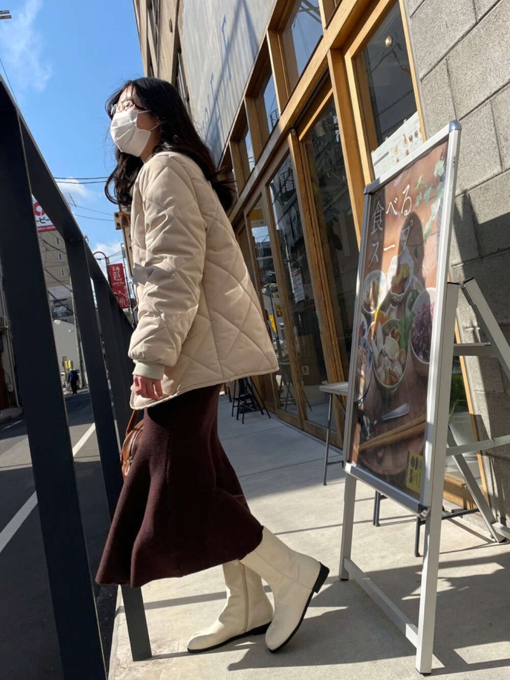 ブラウン系のボストンバッグ、ベージュ系のニット/セーター、ホワイト系のブーツを着用したレディースの冬コーディネートの4枚目の写真