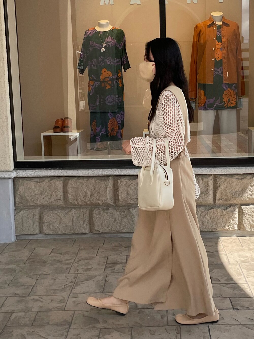 ホワイト系のボストンバッグ、ベージュ系のスカート、ベージュ系のバレエシューズを着用したレディースの夏コーディネートの2枚目の写真