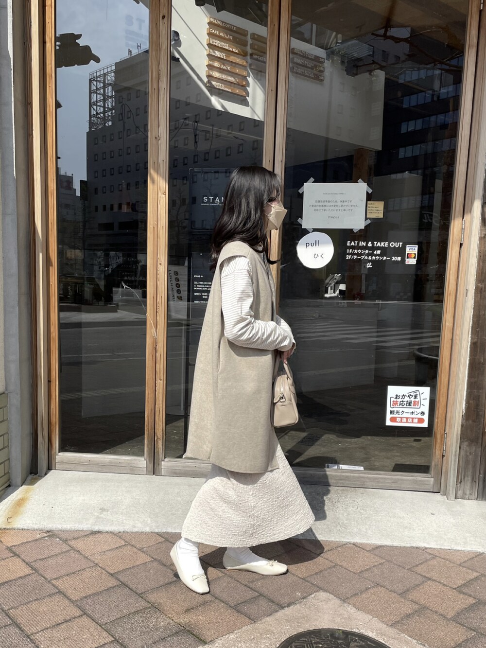 ベージュ系のボストンバッグ、ベージュ系のその他アウター、ブラウン系のその他トップスを着用したレディースの秋コーディネートの2枚目の写真