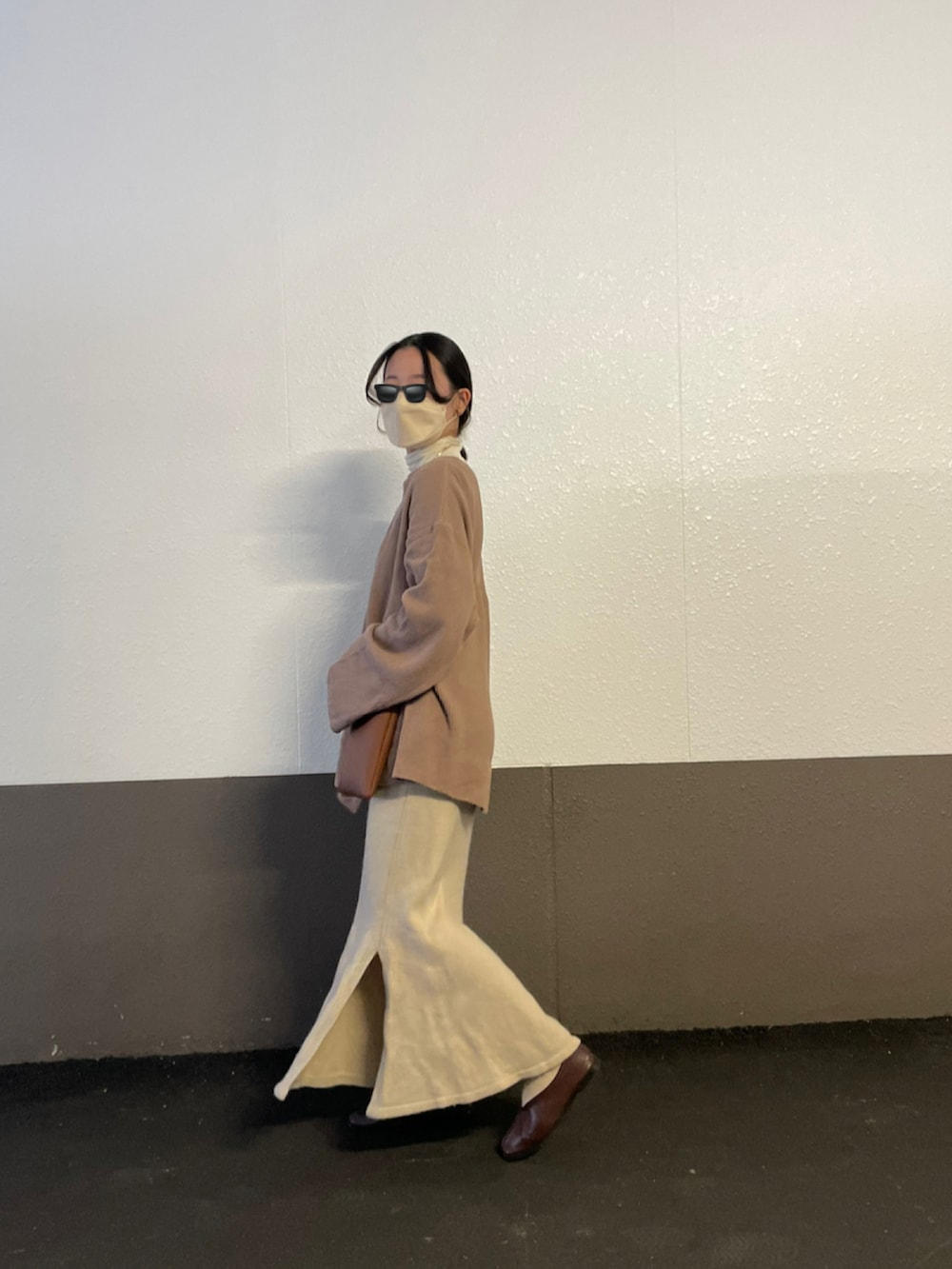 ブラウン系のTシャツ/カットソー、ブラウン系のショルダーバッグ、ベージュ系のスカートを着用したレディースの秋コーディネートの3枚目の写真