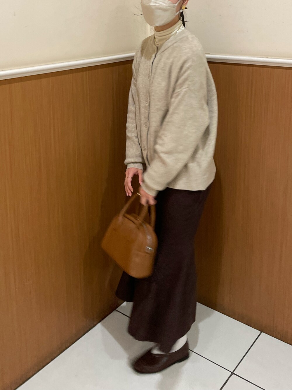 ブラウン系のボストンバッグ、ブラウン系のスカート、ブラウン系のパンプスを着用したレディースの秋コーディネートの2枚目の写真