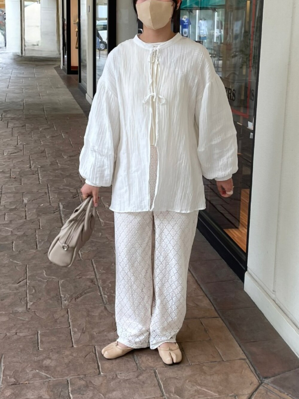 ベージュ系のバレエシューズ、ベージュ系のつなぎ/オールインワン、ホワイト系のニット/セーターを着用したレディースの春コーディネートの4枚目の写真