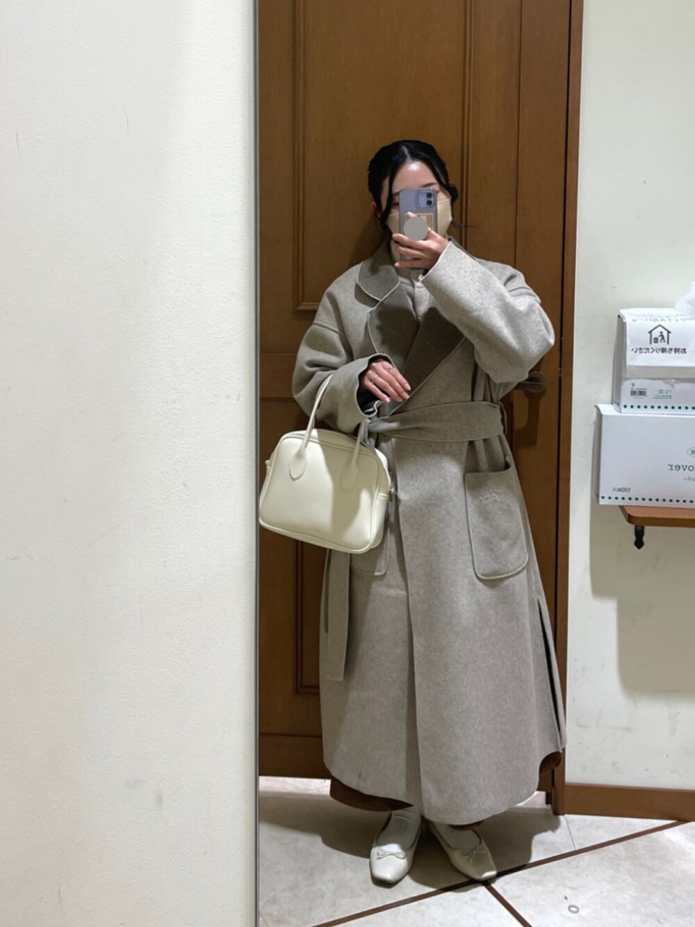 ホワイト系のボストンバッグ、グレー系のその他アウター、ホワイト系のバレエシューズを着用したレディースの冬コーディネートの2枚目の写真