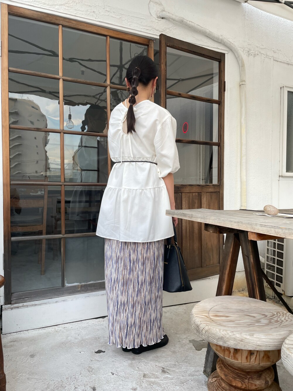 ホワイト系のスカート、ブラック系のバレエシューズ、ホワイト系のシャツ/ブラウスを着用したレディースの夏コーディネートの2枚目の写真