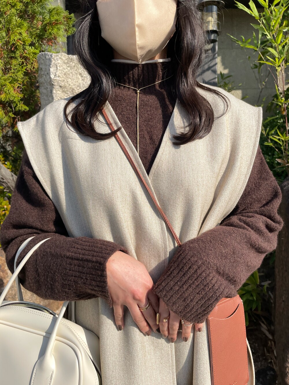 ホワイト系のボストンバッグ、ベージュ系のスカート、ブラウン系のニット/セーターを着用したレディースの冬コーディネートの4枚目の写真