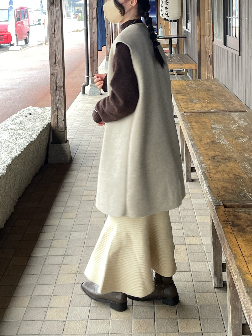 ベージュ系のボストンバッグ、ブラウン系のニット/セーター、ベージュ系のスカートを着用したレディースの春コーディネートの2枚目の写真