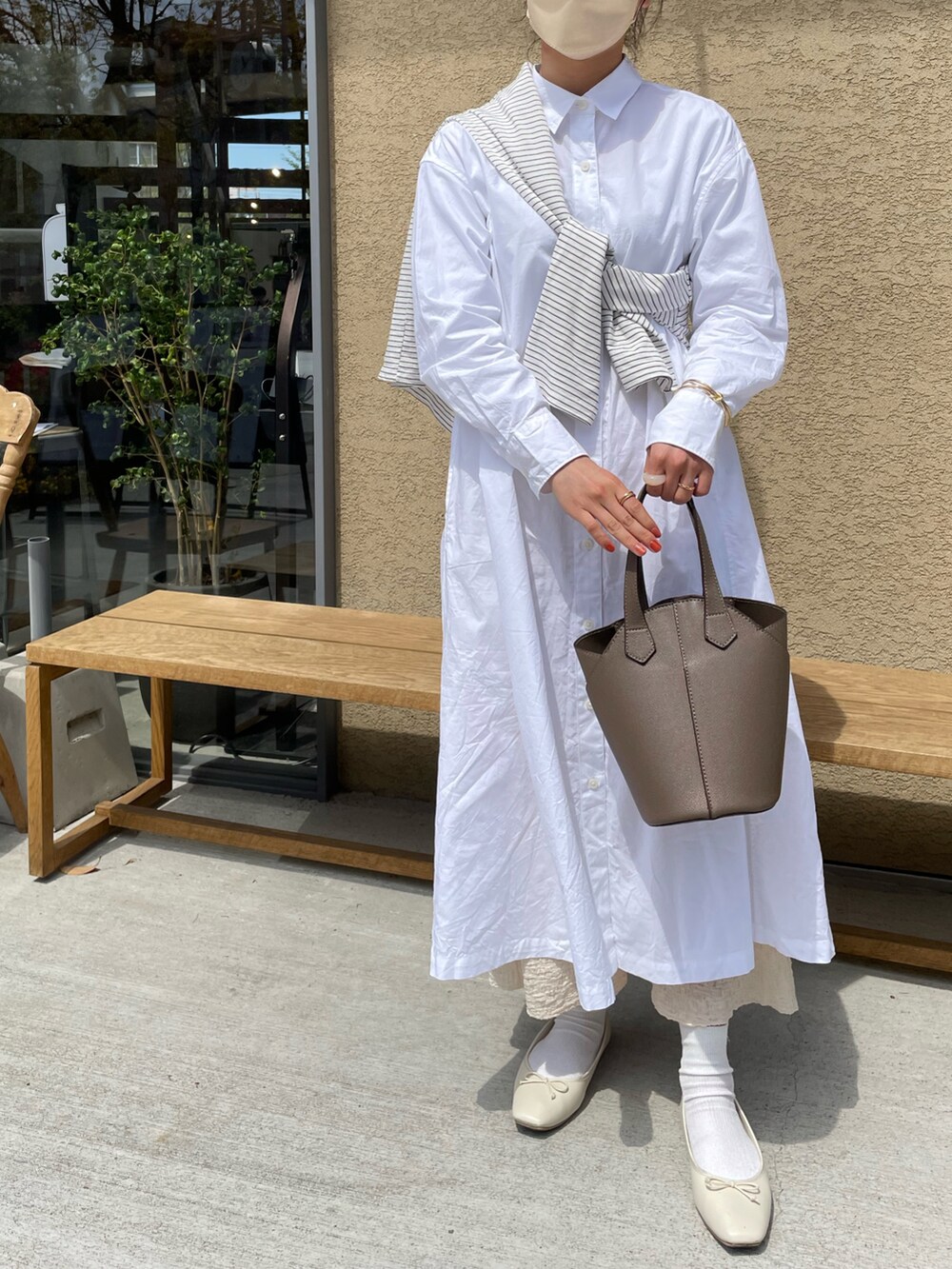 グレー系のバッグ、ホワイト系のバレエシューズ、ベージュ系のスカートを着用したレディースの夏コーディネートの2枚目の写真
