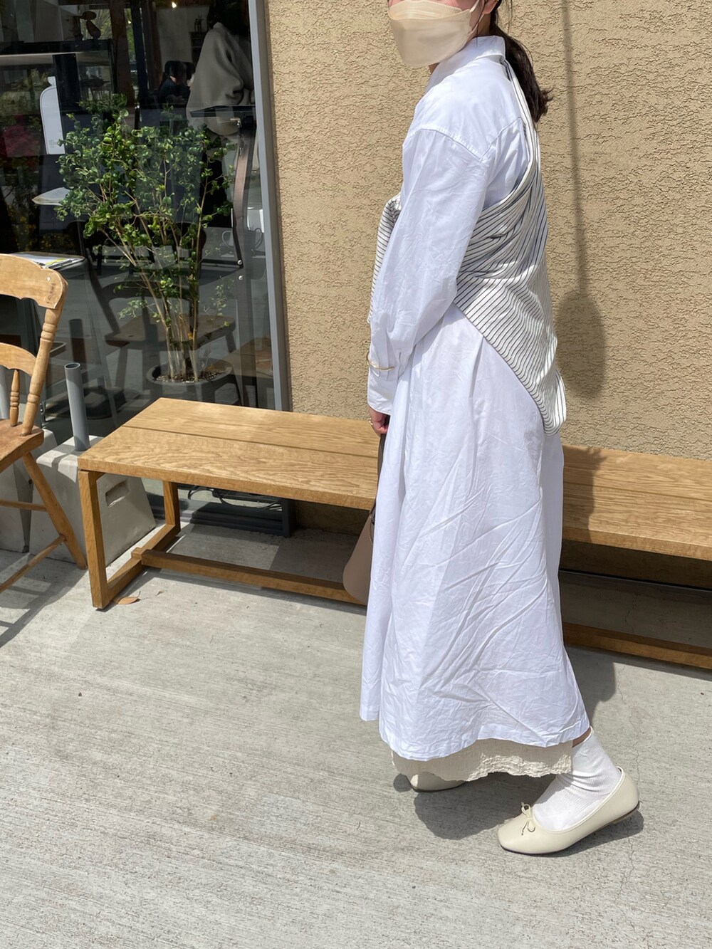 グレー系のバッグ、ホワイト系のバレエシューズ、ベージュ系のスカートを着用したレディースの夏コーディネートの3枚目の写真