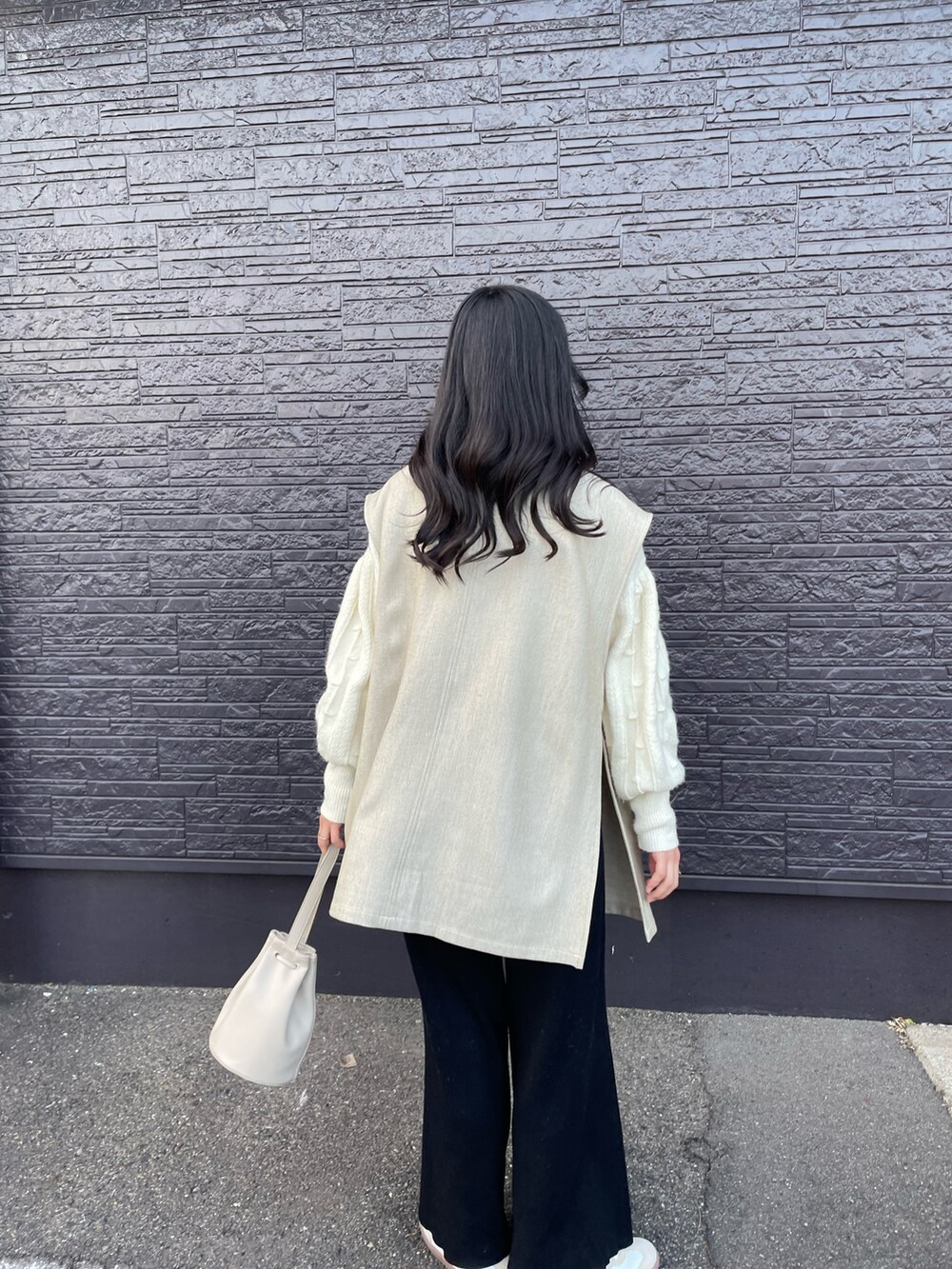 ベージュ系のバッグ、ベージュ系のスニーカー、ブラック系のその他パンツを着用したレディースの春コーディネートの2枚目の写真