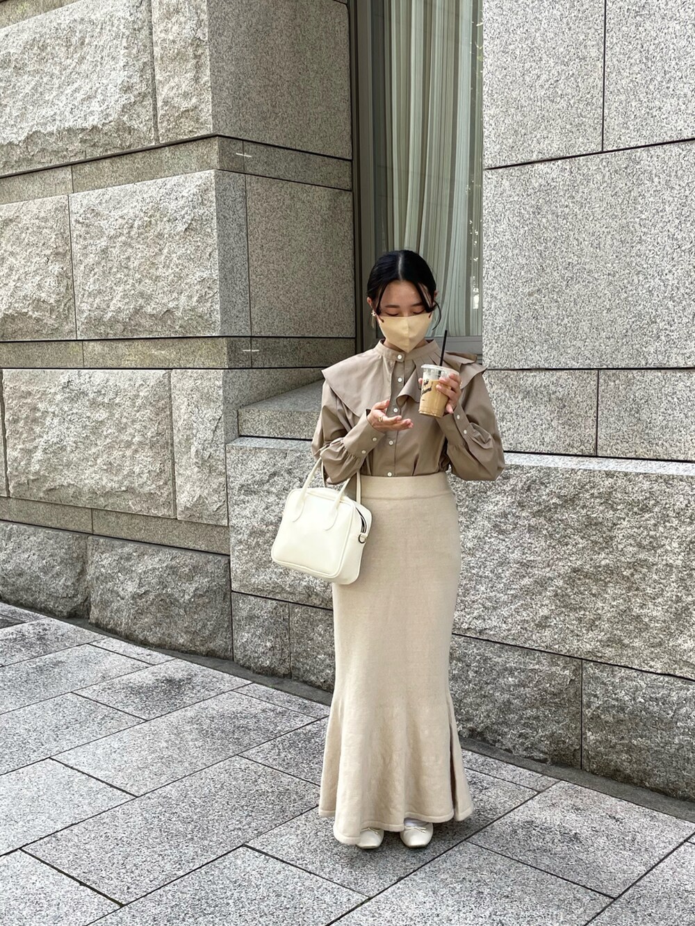 ベージュ系のスカート、ホワイト系のボストンバッグ、ブラウン系のシャツ/ブラウスを着用したレディースの秋コーディネートの4枚目の写真