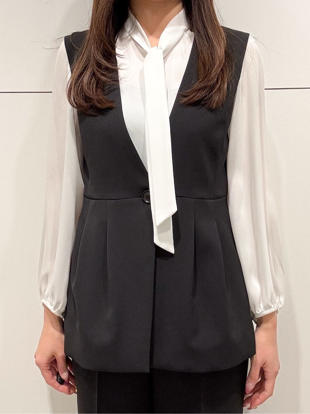 ホワイト系のシャツ/ブラウス、ブラック系のベスト、ブラック系のその他パンツを着用したレディースの冬コーディネートの4枚目の写真