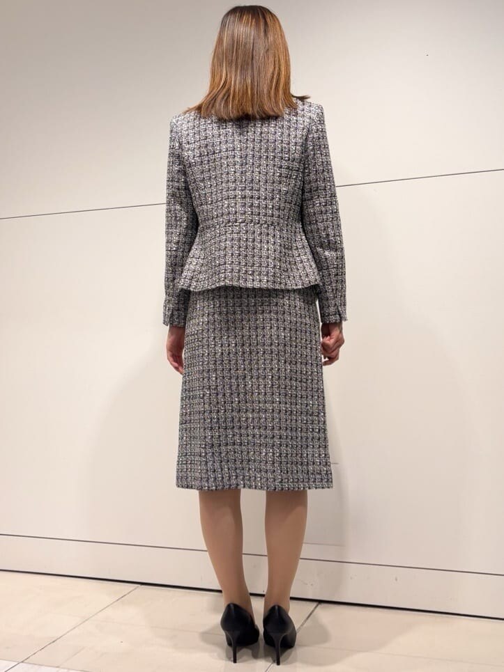 ブラック系のノーカラージャケット、ブラック系のスカート、ブルー系のシャツ/ブラウスを着用したレディースの冬コーディネートの3枚目の写真