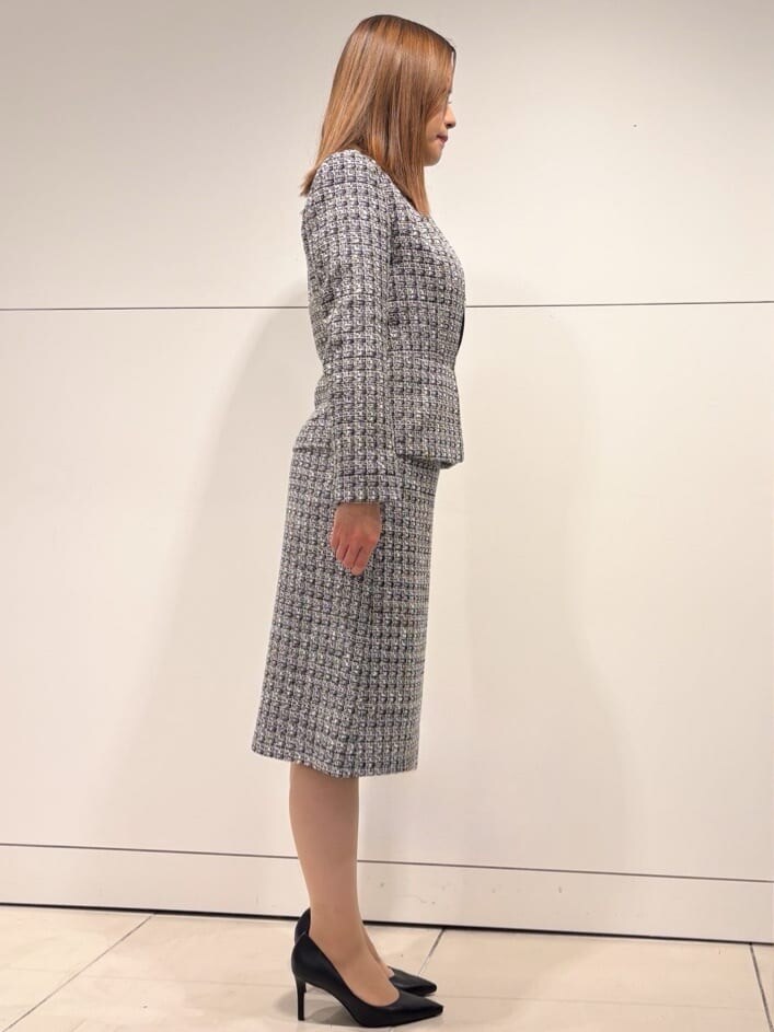 ブラック系のノーカラージャケット、ブラック系のスカート、ブルー系のシャツ/ブラウスを着用したレディースの冬コーディネートの2枚目の写真