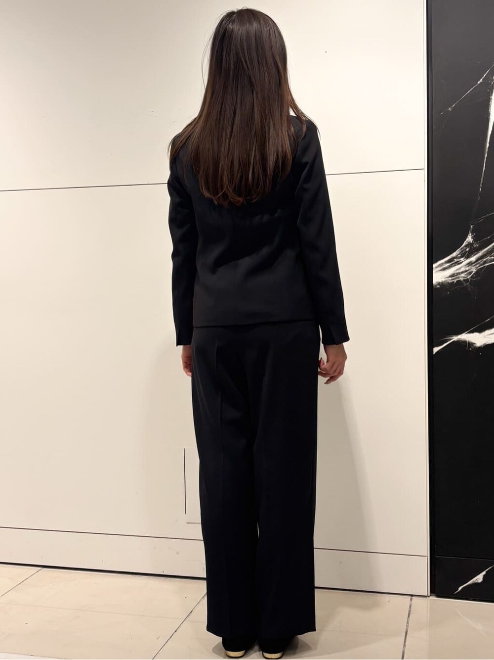 ホワイト系のシャツ/ブラウス、ブラック系のテーラードジャケット、ブラック系のその他パンツを着用したレディースの冬コーディネートの3枚目の写真