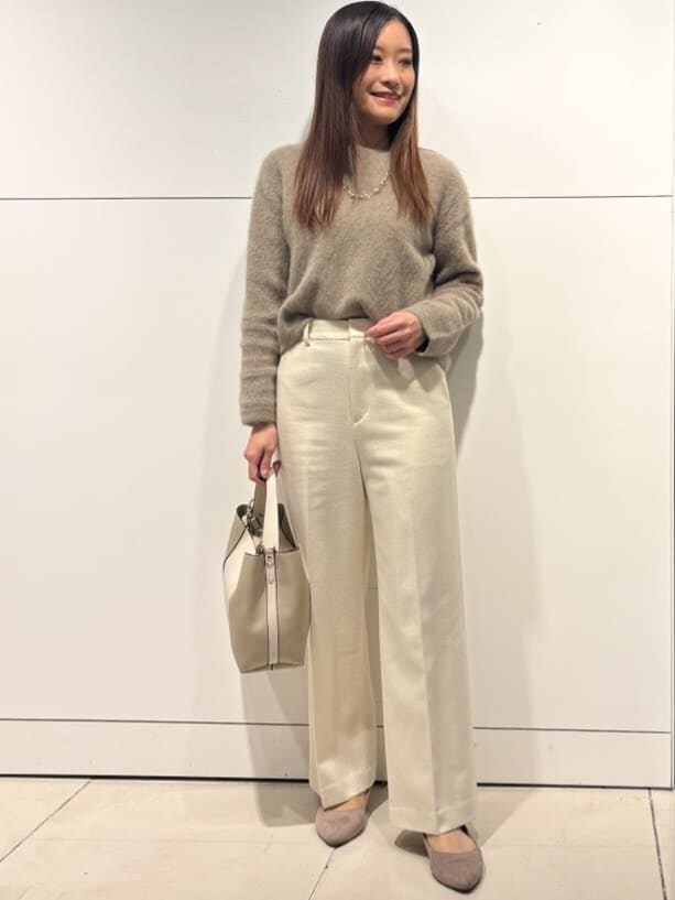 ベージュ系のニット/セーター、ベージュ系のショルダーバッグ、ホワイト系のその他パンツを着用したレディースの冬コーディネートの6枚目の写真