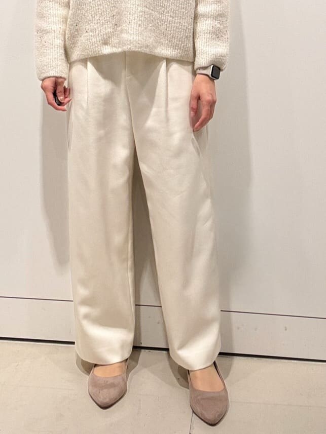 ホワイト系のニット/セーター、ホワイト系のその他パンツ、ブラウン系のダウンジャケット/コートを着用したレディースの冬コーディネートの7枚目の写真
