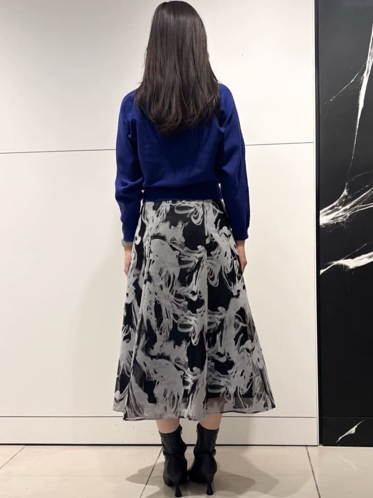 グレー系のスカート、グレー系のその他アウター、シルバー系のネックレスを着用したレディースの冬コーディネートの7枚目の写真