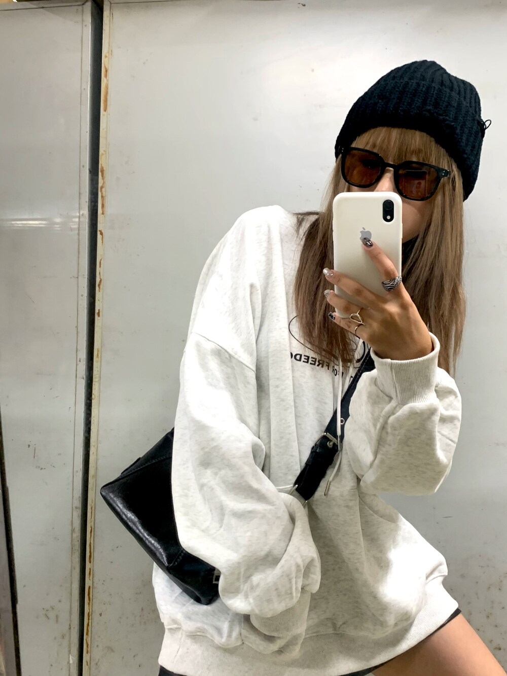 ベージュ系のパーカー、ブラック系のショルダーバッグ、ブラック系のニットキャップ/ビーニーを着用したレディースの秋コーディネートの2枚目の写真