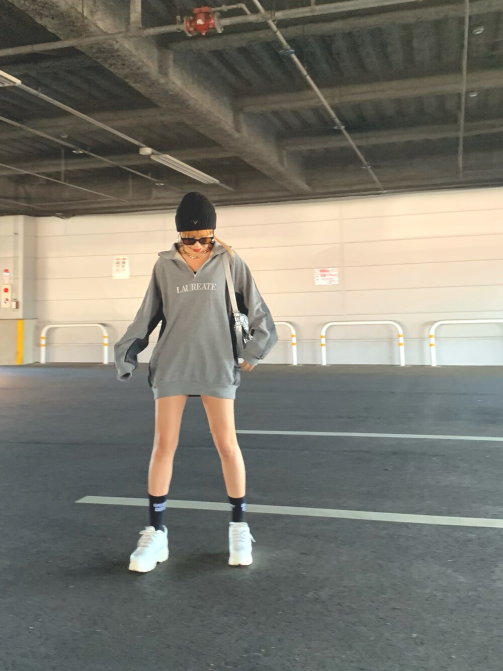 シルバー系のショルダーバッグ、ブラック系のニットキャップ/ビーニー、ブラック系のソックス/靴下を着用したレディースの冬コーディネートの2枚目の写真