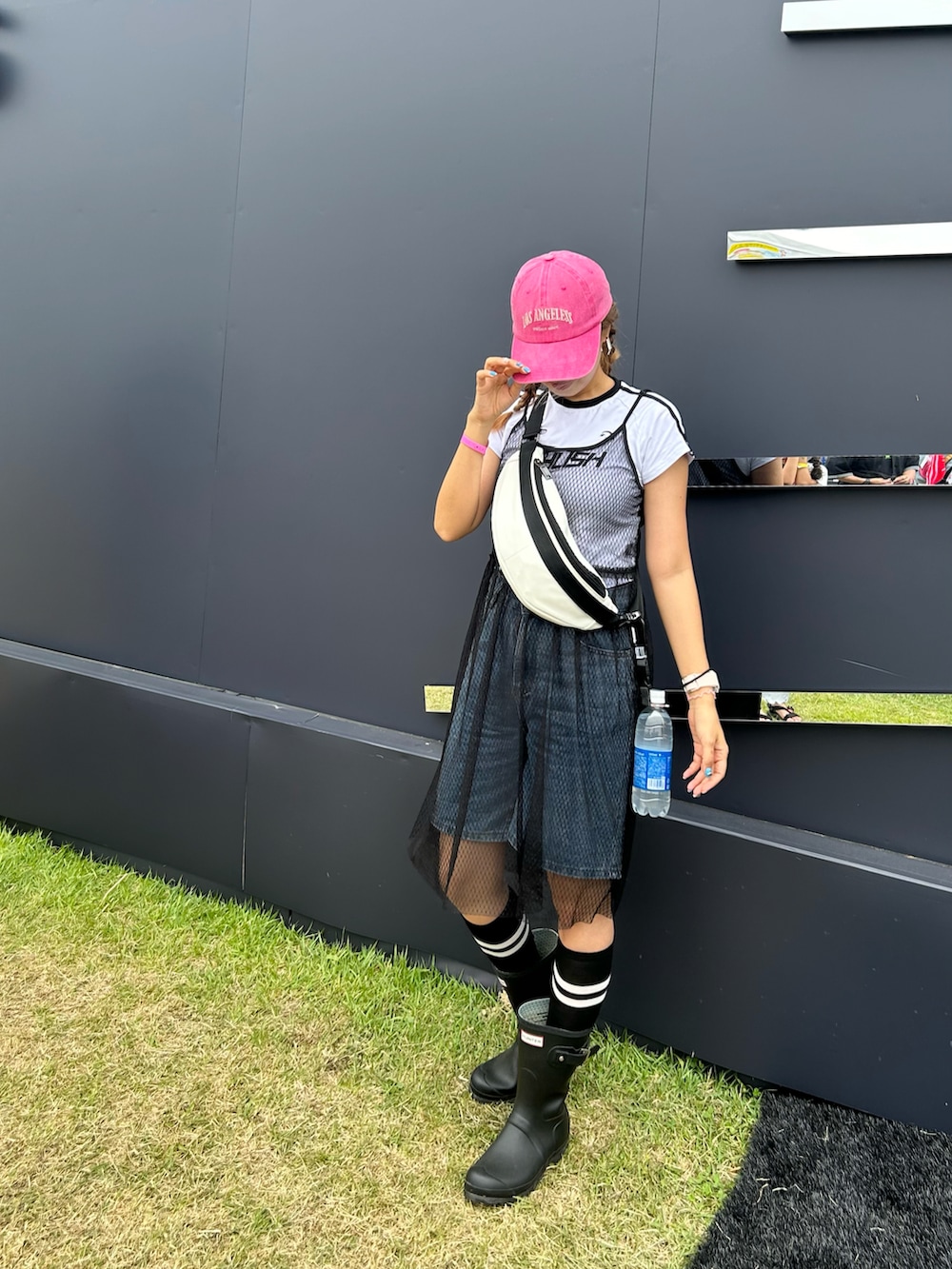 ブラック系のブーツ、ホワイト系のボディバッグ/ウエストポーチ、ブルー系のデニムパンツを着用したレディースの夏コーディネートの3枚目の写真