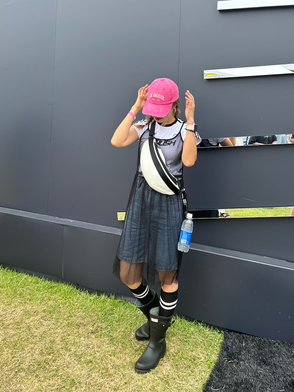 ブラック系のブーツ、ホワイト系のボディバッグ/ウエストポーチ、ブルー系のデニムパンツを着用したレディースの夏コーディネートの2枚目の写真