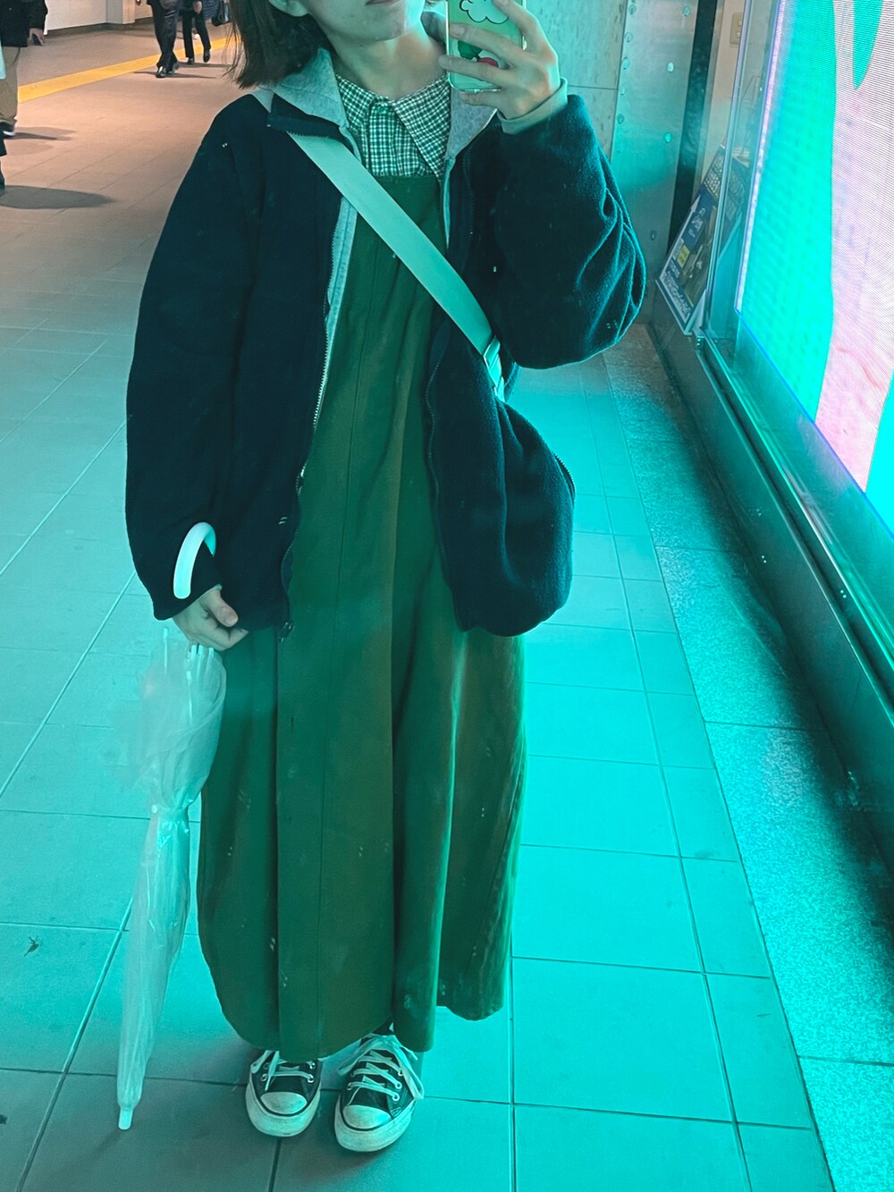 ブラック系のスニーカー、グリーン系のジャンパースカート、グリーン系のシャツ/ブラウスを着用したレディースの秋コーディネートの2枚目の写真