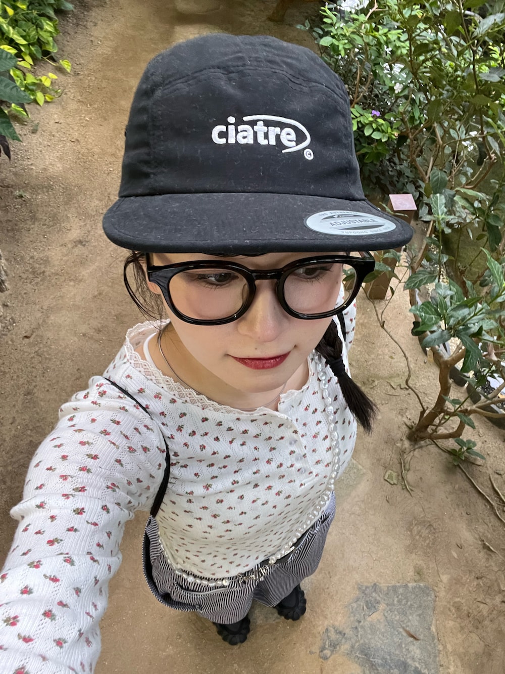 ブラック系のバックパック/リュック、レッド系のTシャツ/カットソー、ブルー系のデニムパンツを着用したレディースの秋コーディネートの2枚目の写真