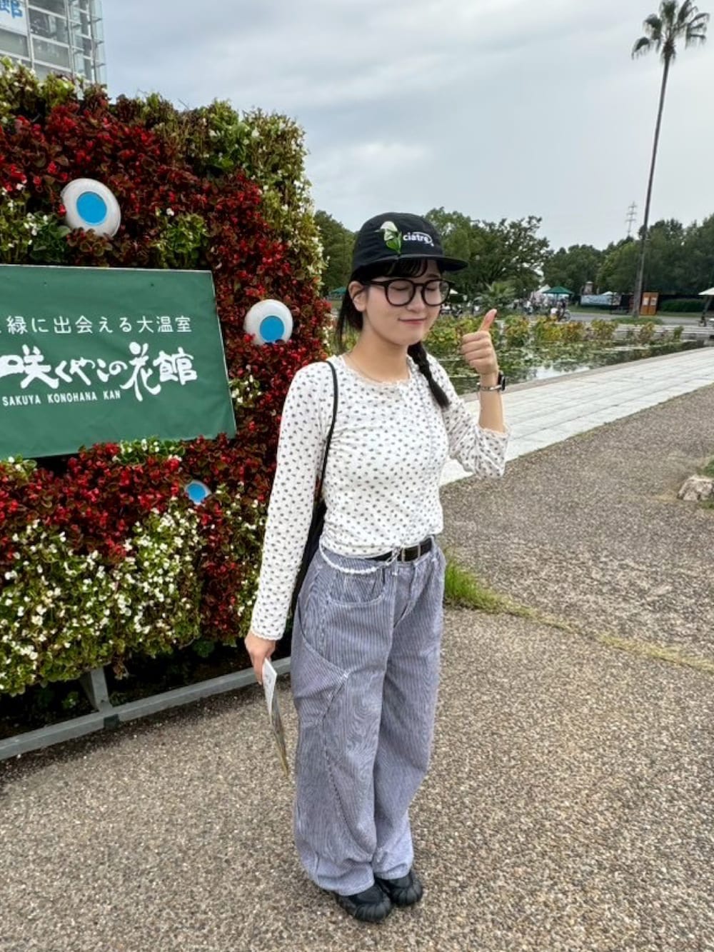 ブラック系のバックパック/リュック、レッド系のTシャツ/カットソー、ブルー系のデニムパンツを着用したレディースの秋コーディネートの3枚目の写真