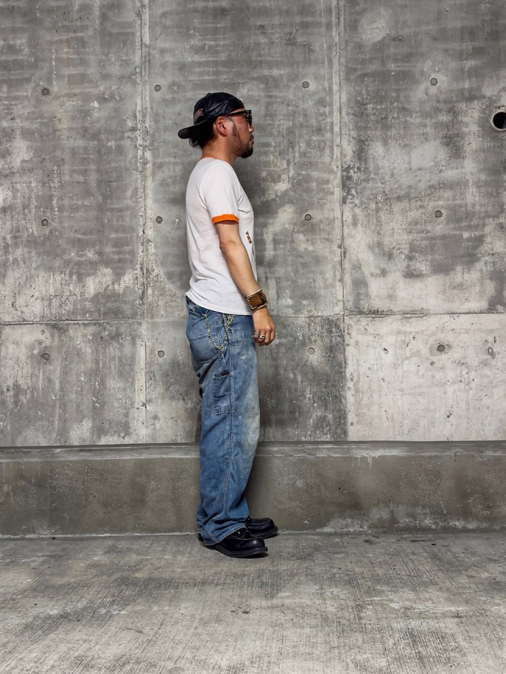 ブラック系のブーツ、ホワイト系のTシャツ/カットソー、ブルー系のサロペット/オーバーオールを着用したメンズの夏コーディネートの2枚目の写真