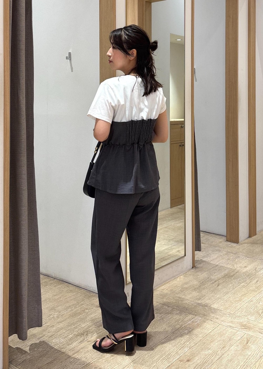 ブラック系のサンダル、グレー系のTシャツ/カットソー、グレー系のスラックスを着用したレディースの夏コーディネートの2枚目の写真