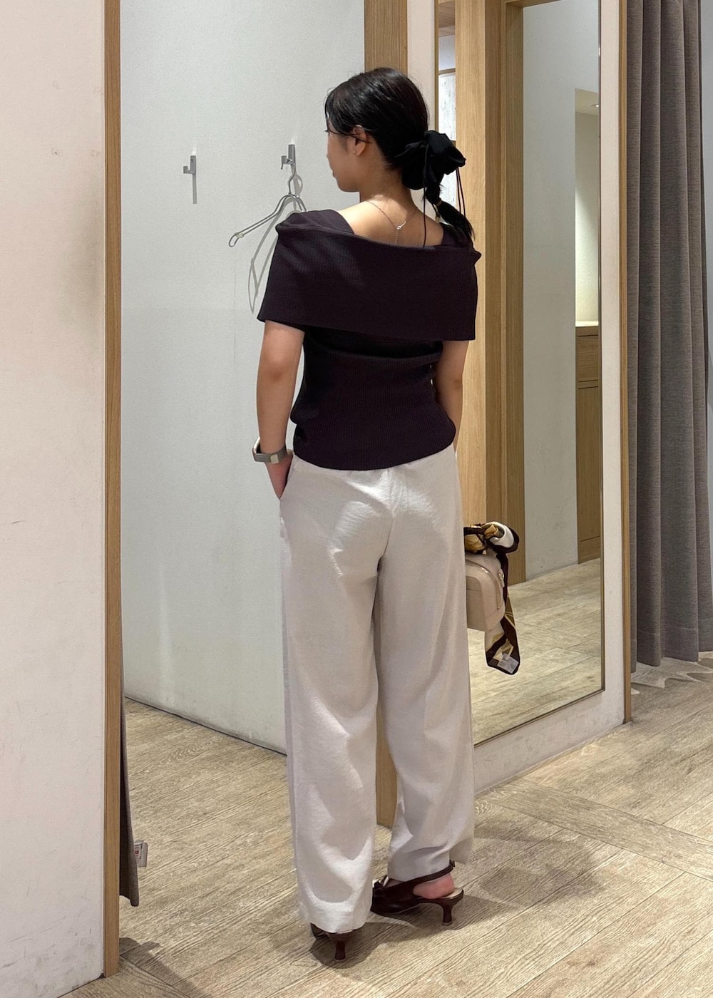 ブラウン系のパンプス、ホワイト系のスラックス、グレー系のニット/セーターを着用したレディースの秋コーディネートの3枚目の写真