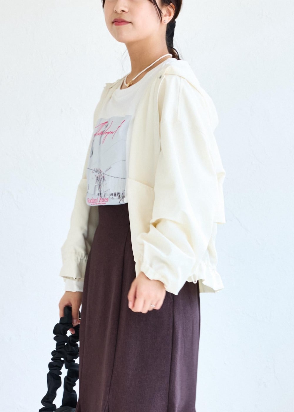 ホワイト系のショルダーバッグ、ブラウン系のスカート、ホワイト系のTシャツ/カットソーを着用したレディースの夏コーディネートの7枚目の写真