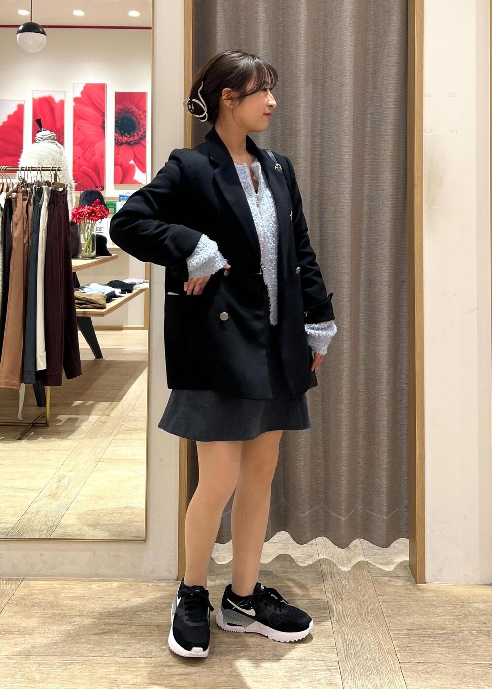 ブラック系のテーラードジャケット、ブラック系のスニーカー、ブルー系のカーディガン/ボレロを着用したレディースの冬コーディネートの3枚目の写真