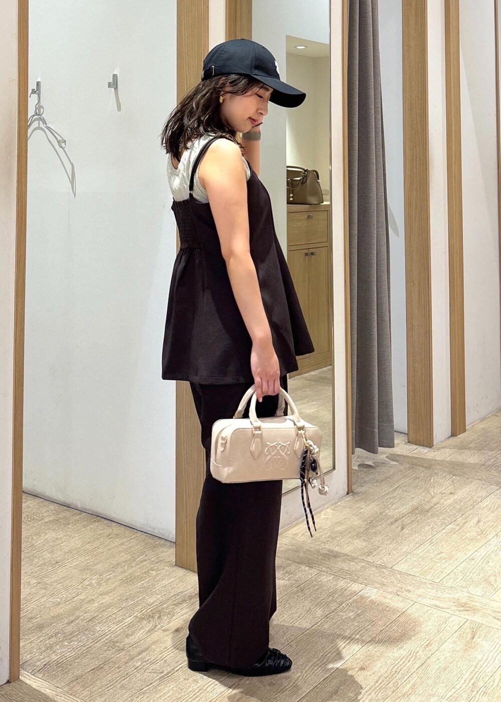 ベージュ系のボストンバッグ、ブラウン系のスラックス、ブラウン系のキャミソールを着用したレディースの秋コーディネートの4枚目の写真