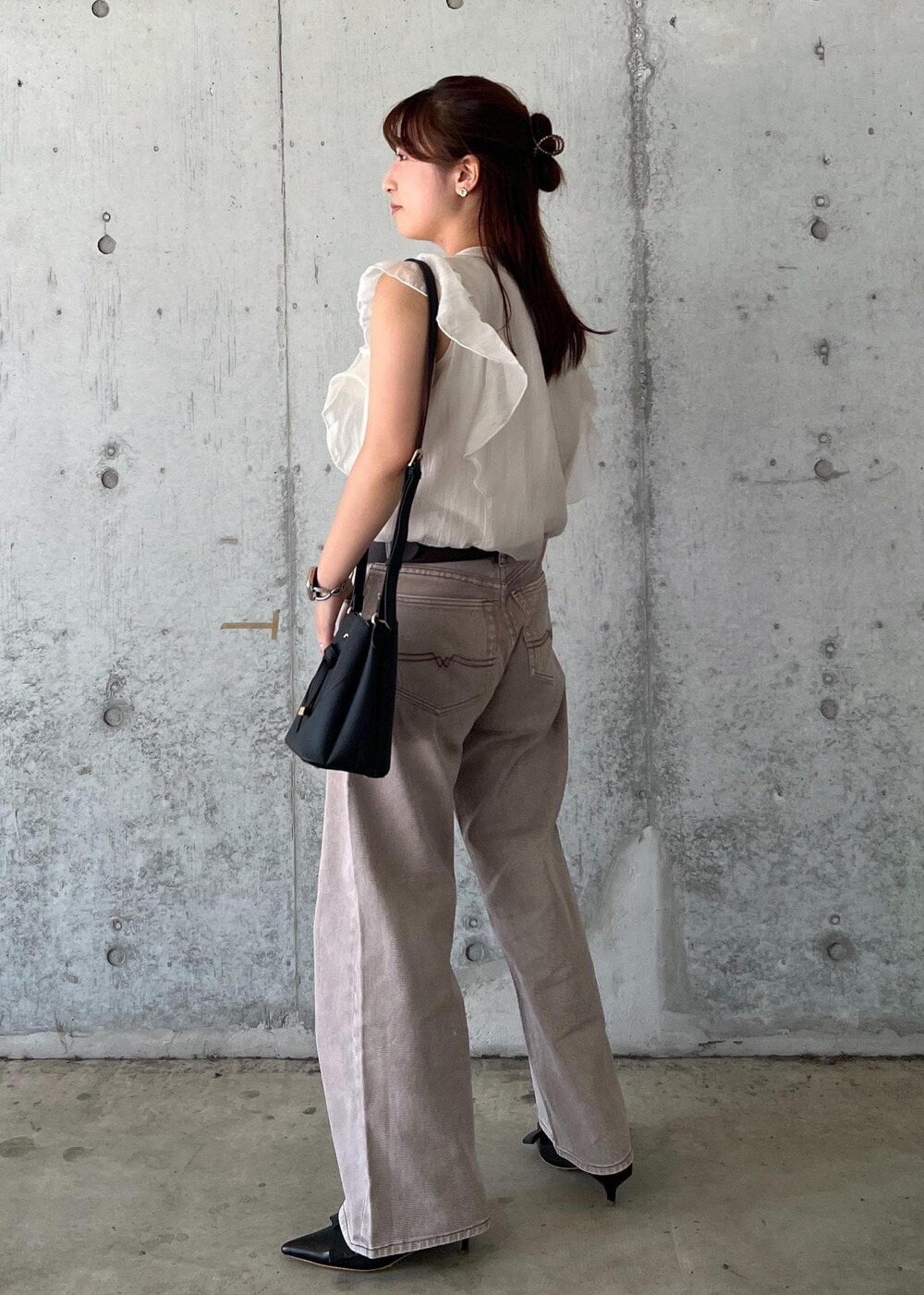 ブラック系のパンプス、ホワイト系のシャツ/ブラウス、ブラック系のショルダーバッグを着用したレディースの夏コーディネートの3枚目の写真