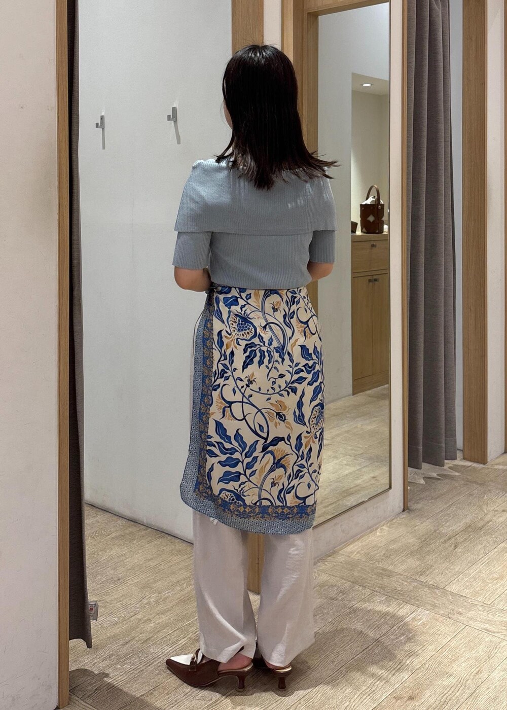 ブラウン系のパンプス、グリーン系のニット/セーター、ホワイト系のスラックスを着用したレディースの夏コーディネートの4枚目の写真