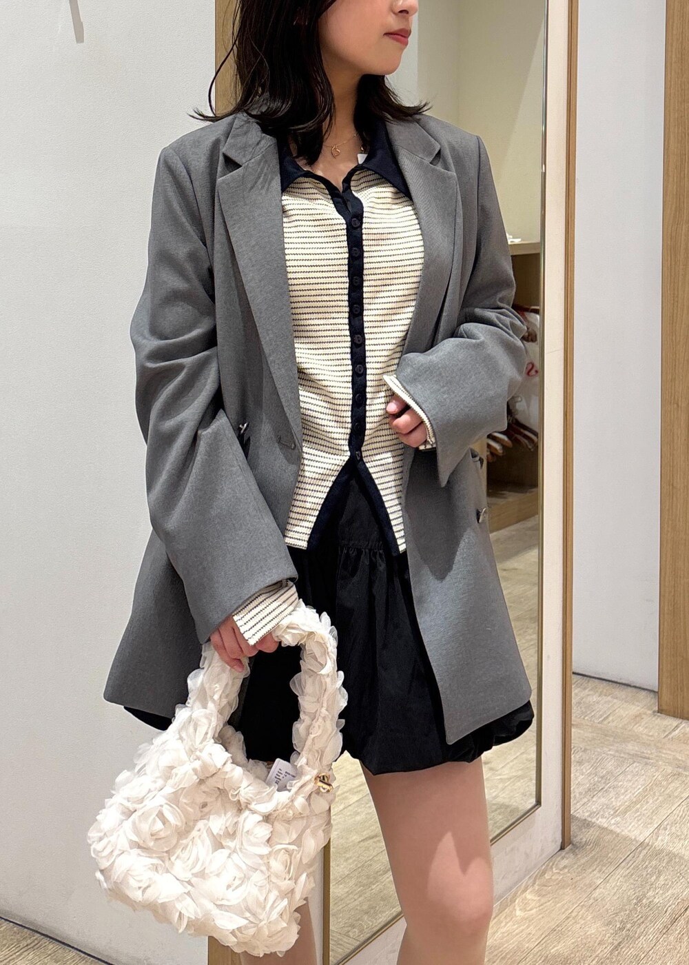 グレー系のテーラードジャケット、ブラック系のローファー、ブラック系のスカートを着用したレディースの春コーディネートの5枚目の写真