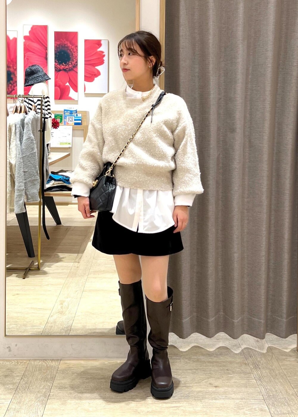 ブラウン系のブーツ、ホワイト系のシャツ/ブラウス、ベージュ系のニット/セーターを着用したレディースの冬コーディネートの2枚目の写真