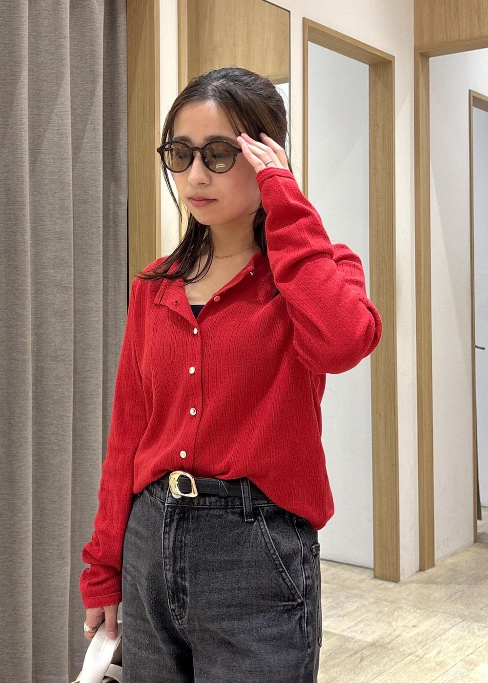 ブラウン系のパンプス、レッド系のカーディガン/ボレロ、ブラック系のデニムパンツを着用したレディースの春コーディネートの6枚目の写真