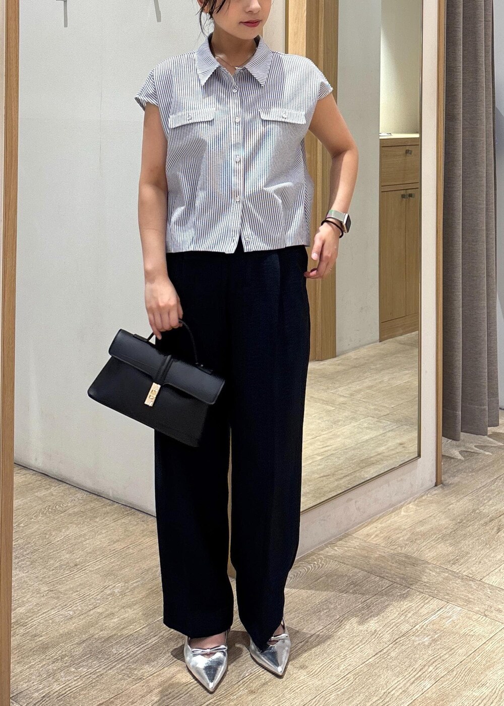 ブラック系のショルダーバッグ、シルバー系のパンプス、ブラック系のシャツ/ブラウスを着用したレディースの夏コーディネートの4枚目の写真