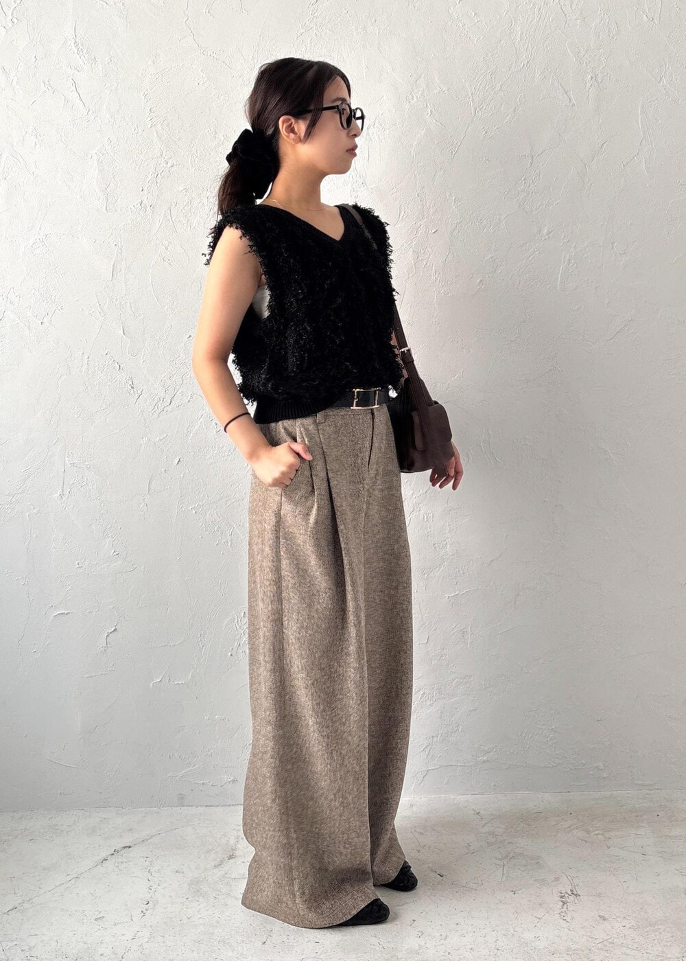 ブラック系のパンプス、ブラック系のベスト、ブラウン系のショルダーバッグを着用したレディースの夏コーディネートの2枚目の写真